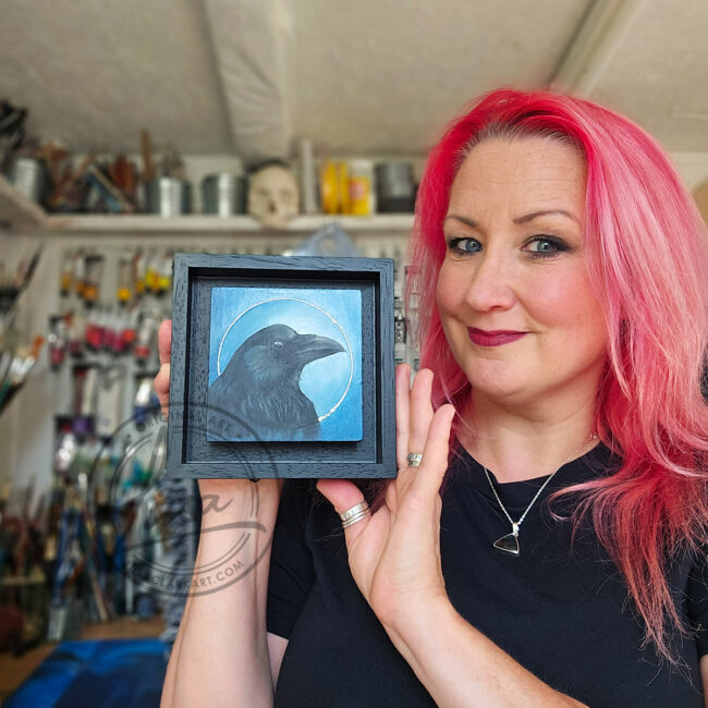 Liisa Clark holding The Blue Corvidae Series by Liisa Clark Art 4 oil Painting Portraits of British Corvids on Cradled Birch Wood Panels The Crow Floating in a Black Wood Frame