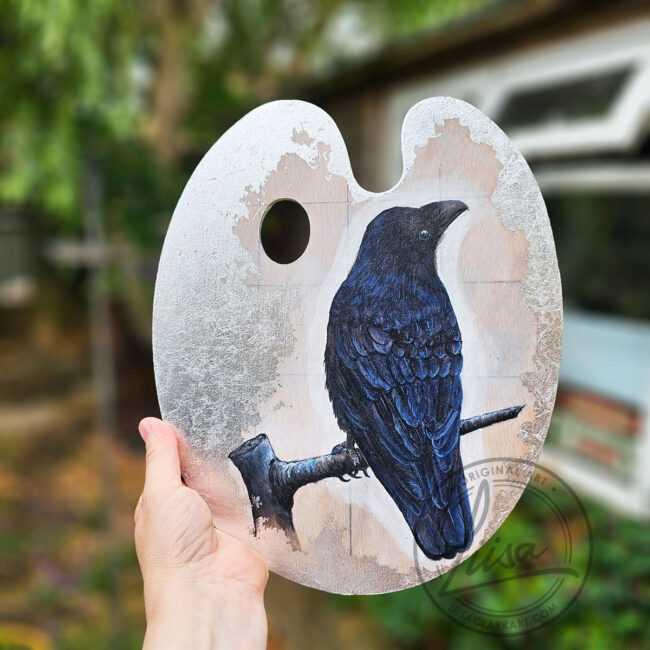Close up of Original Painting of a Crow on an Artist palette set with Silver Leaf in a Black Frame by Liisa Clark