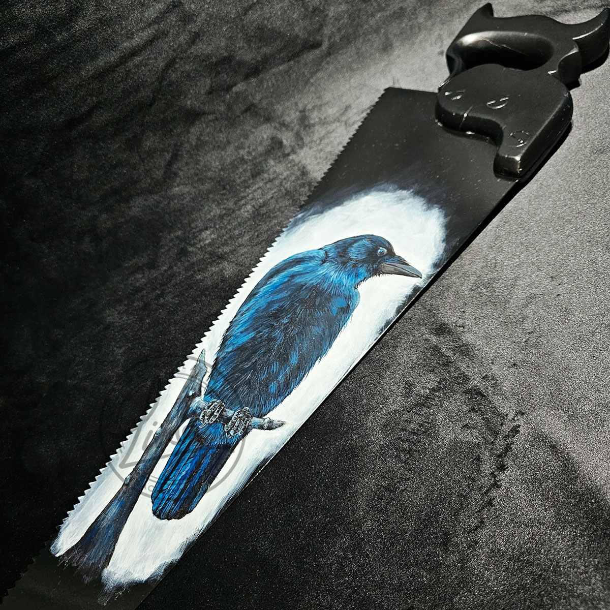 Photo of the Morrigan Crow painting on an antique Saw with a Dark painted Handle set with a dark back ground dark nature art inspired by mythology