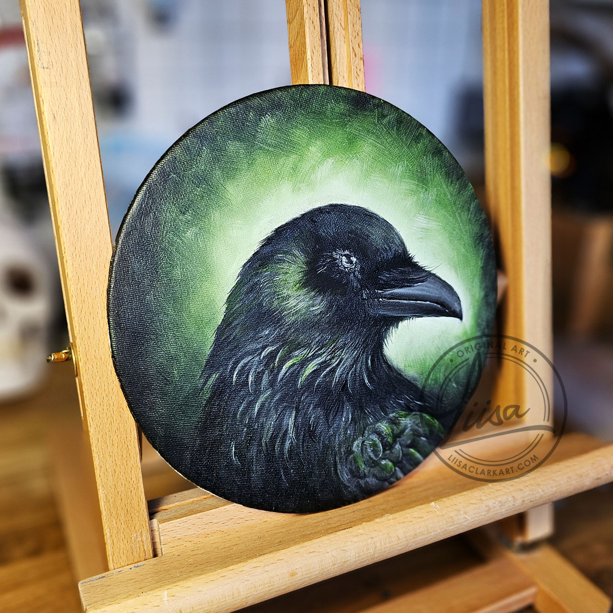 Set on an Easel An Original Oil Painting titled Verdant Green on a Round Canvas Panel part of the Corvid Chroma Series Celebrating the Colours found in Corvid feathers by Liisa Clark