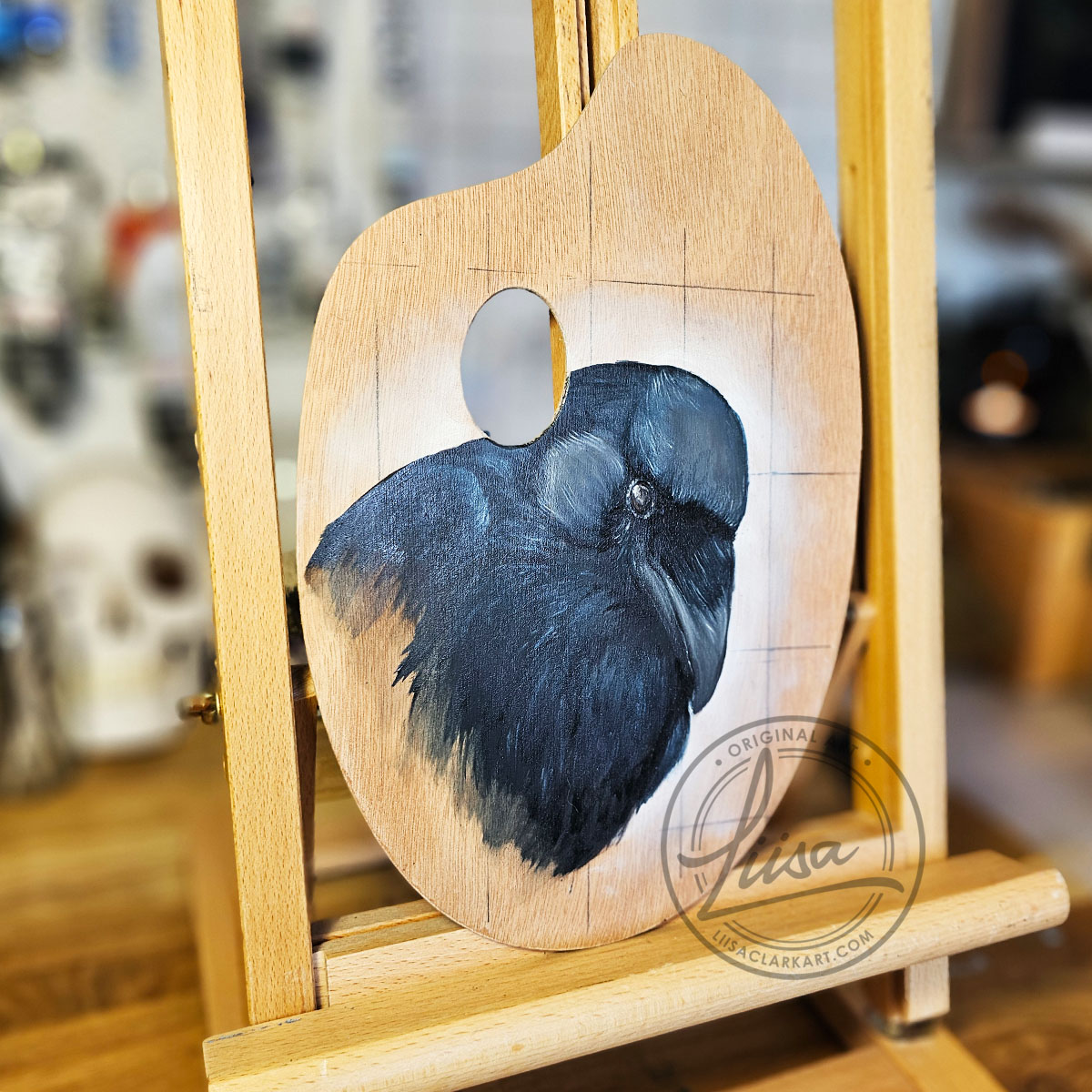 Angled view of crow oil painting on a wooden palette by Liisa Clark Art