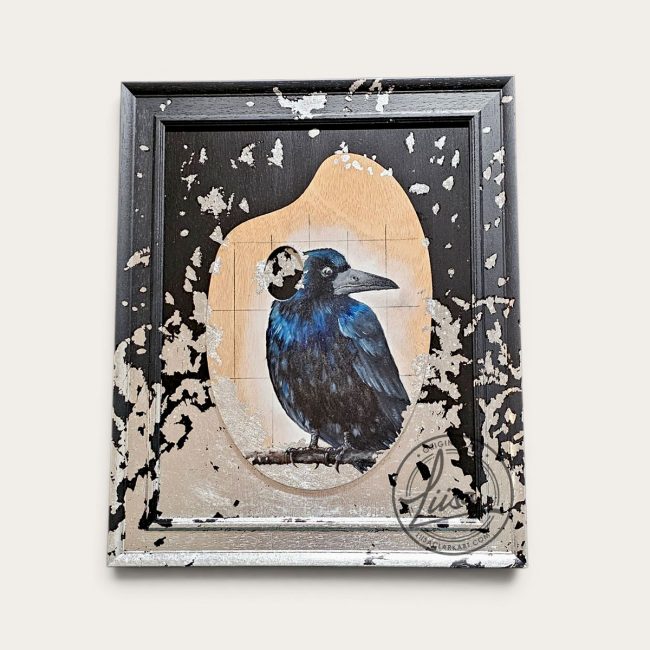 Original rook artwork painted on a reclaimed artist's palette with hand-applied silver leaf, mounted and framed in black wood as part of the All That Glitters series by Liisa Clark.