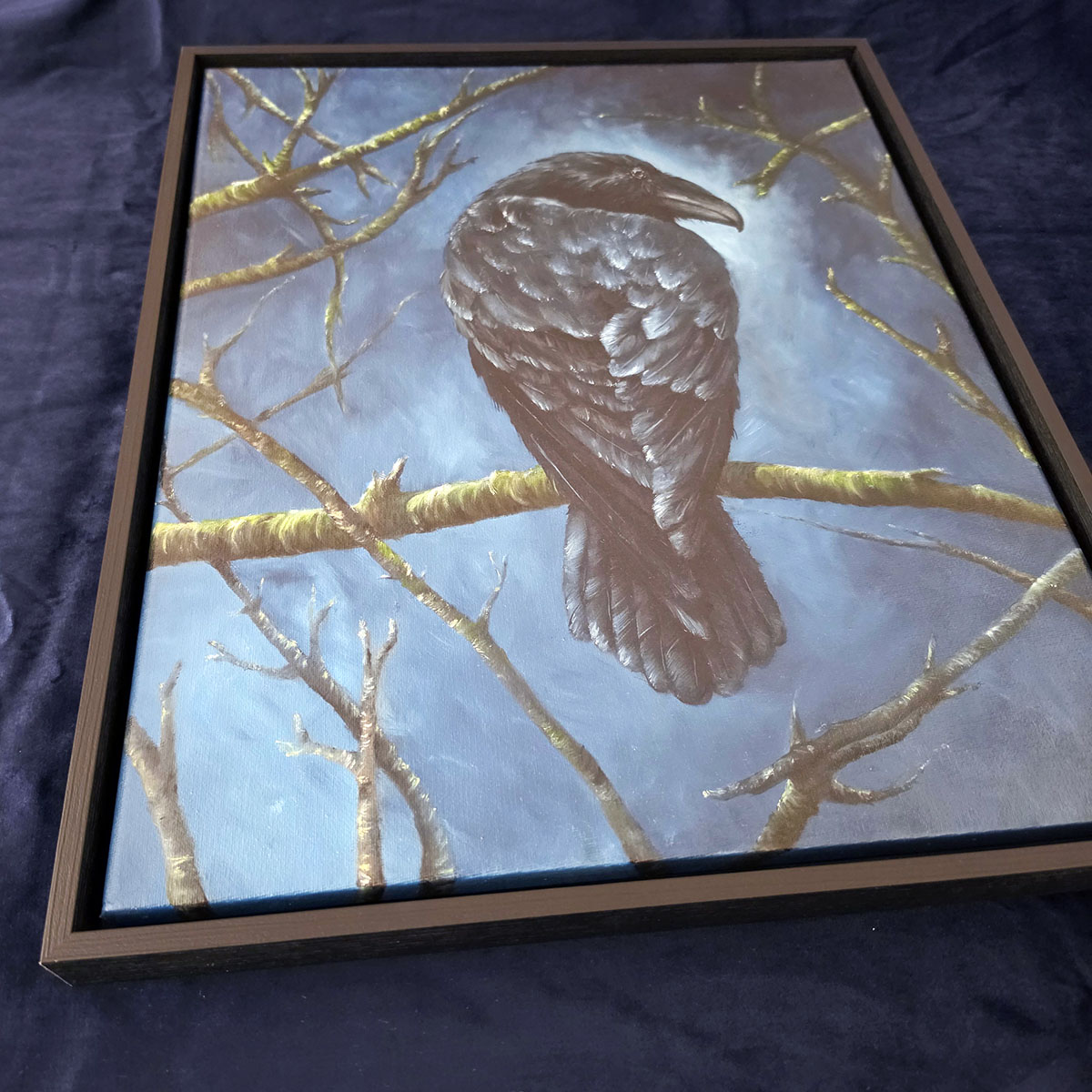 Close angled view of The Watchful Guardian crow oil painting showing canvas and black frame